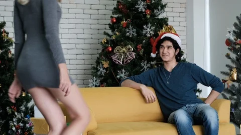 Young man give the Christmas gift to his young girlfriend with Christmas tree Stock Footage 120362753