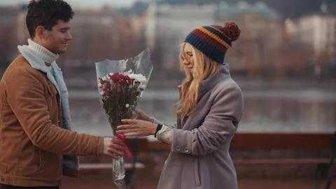 Young man giving bloom flower bouquet to woman on Valentine day, first date 库存影片 136091877