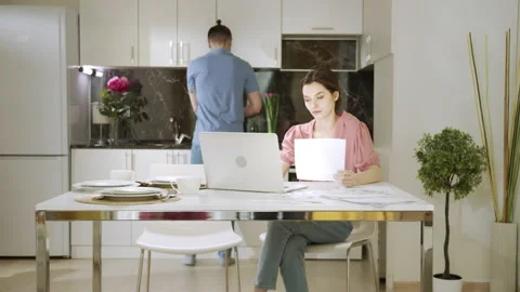 A young man is giving a cup of tea to her working wife Stock Footage 156001126