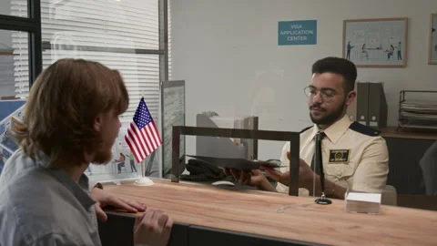 Young Man Giving Documents to Visa Processing Officer who Verifying Identity Stock Footage 311027171