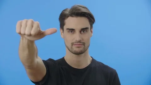 Young man giving a thumbs down sign 4K Stock Footage 88399827
