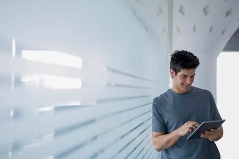 Young man in glass office using digital tablet Stock Photos
