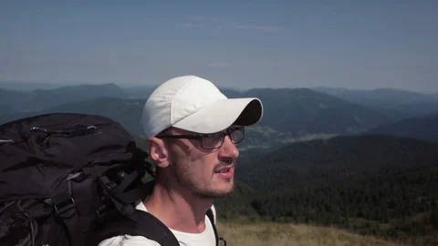Young man in glasses and a baseball cap hiking in mountain outdoor nature Stock-Footage 88973092