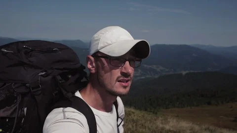 Young man in glasses and a baseball cap hiking in mountain outdoor nature Stock-Footage 88973246
