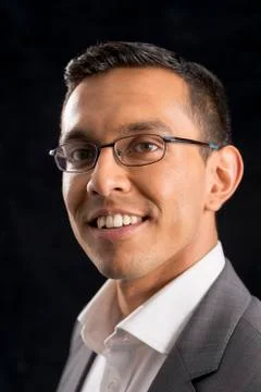 Young Man in Glasses and Gray Coat Over Black Background Stock Photos