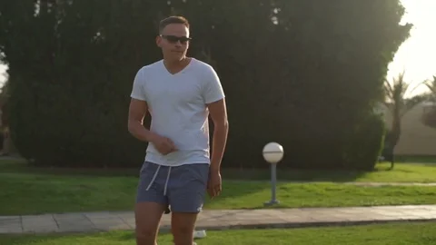 Young man in glasses dancing in the yard slow motion Stock Footage