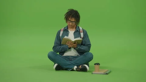 Young Man in Glasses Looking to Book,Turning Pages of Book. Green Screen Stock Footage 219745342