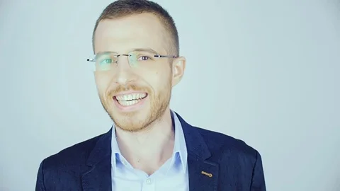 A young man in glasses looks at the camera and laughs. Stock Footage 84224374
