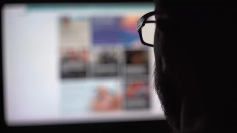 Young man with glasses looks at a computer monitor Stock Footage 128332151