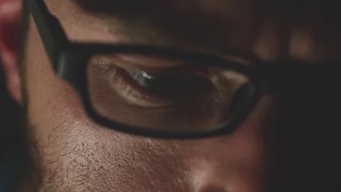 Young man with glasses looks down at night, slow motion shot Stock Footage 79640300