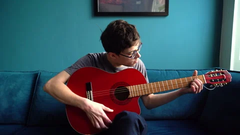Young Man with Glasses playing Guitar Chords Stock Footage 274188039