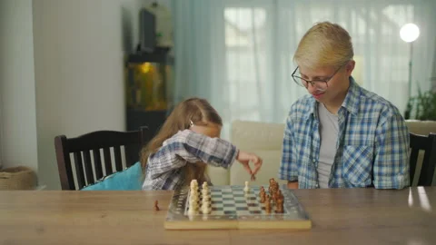 Young Man In Glasses Plays Chess With His Sister Girl At Home. Video stock 145326435