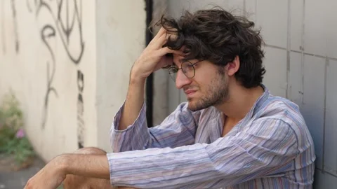 Young man with glasses sad in front of closed shop Video stock 277610503