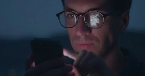 Young man in glasses scroll page app on smartphone, browse social network Stock Footage 228898227