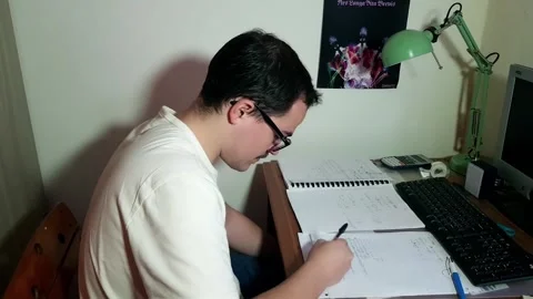 Young man with glasses studying concentrated at his desk with his computer Stock Footage 243126460