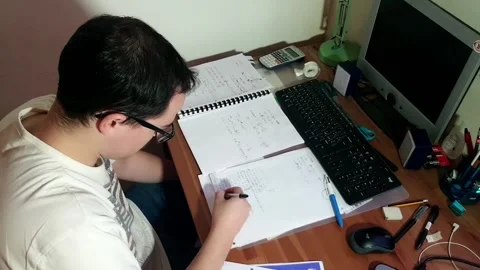Young man with glasses studying concentrated at his desk with his computer Stock Footage 243126471
