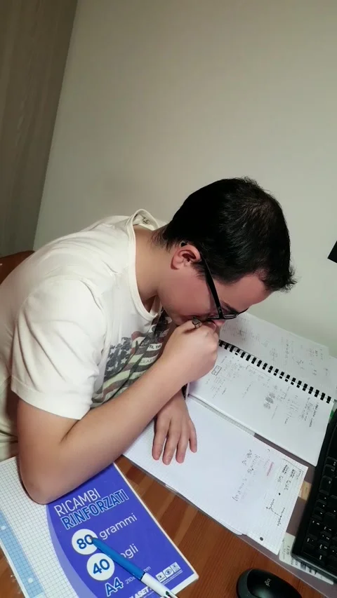 Young man with glasses studying concentrated at his desk with his computer Stock Footage 243126489