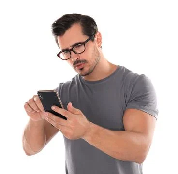 Young man with glasses using mobile phone on white background. Vision problem Stock Photos