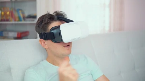 A young man with glasses of virtual reality In a bright interior Video stock 102186973