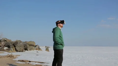 A young man with glasses virtual reality.Coast in the spring Stock-Footage 75007906