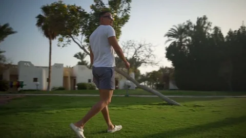 Young man in glasses walking in the yard slow motion Stock Footage 74269229