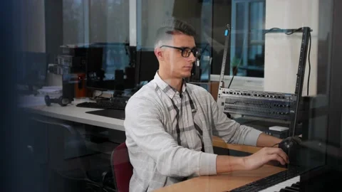 Young man in glasses working at the computer at his workplace in the office Stock Footage 144945445