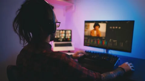 Young man in glasses working on video editing on computer doing montage and Stock Footage 232226847