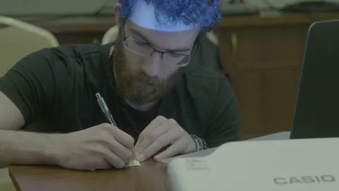Young Man with Glasses Writing on Sticky Notes Stock Footage 341863367