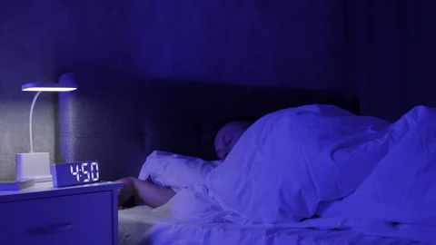 Young man goes to bed, lying in bed and covering with a blanket Stock Footage 290308860