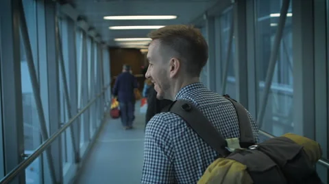 The young man goes down the hall to board the aircraft Stock Footage 64044487