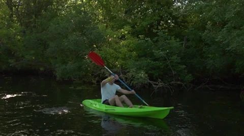 Young man goes kayaking on the river sunrise among reeds Stock Footage 39839962