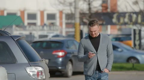 The young man goes on the parking and thumbs through a news Video stock 62112656