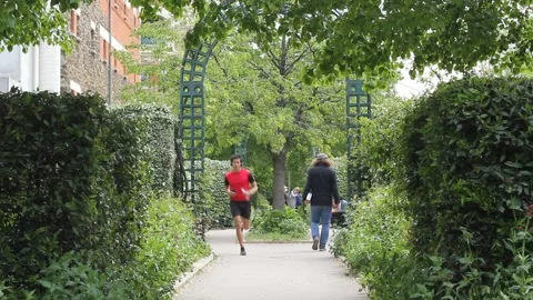 Young man gogging towards the camera at  "La promenade plantée" in Paris Stock Footage 153759360