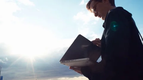 Young man going along street using laptop talking on video call Stock Footage 77168016