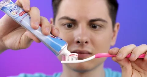 A young man is going to brush his teeth, prepares a paste and a brush Stock Footage 161878904