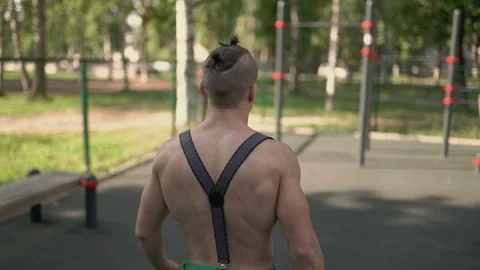 Young man going to do a gymnastic exercise on a horizontal bar Stock Footage 92313589