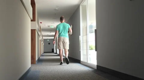 Young man going to his room through luxury hotel hallway. Stock Footage 53490707