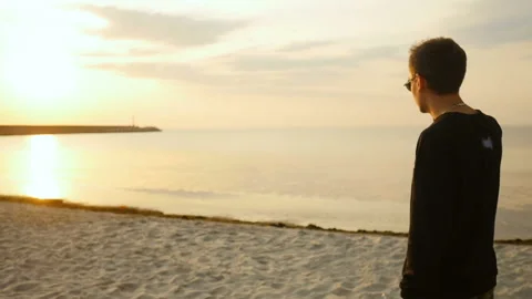 Young man going in the sunlight in beach Stock Footage 96997853