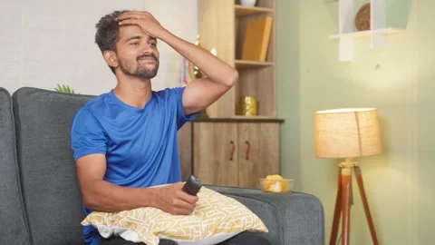 Young man got angry due to loss while watching cricket sports match on tv or Video stock 221139742