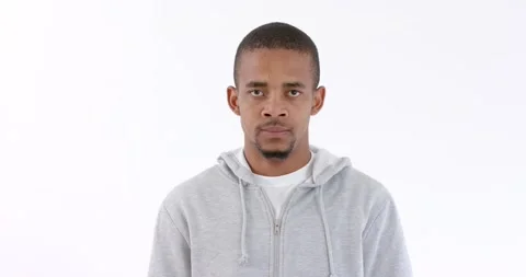 Young man in gray hoodie expressing anger against white background Stock Footage 346028652