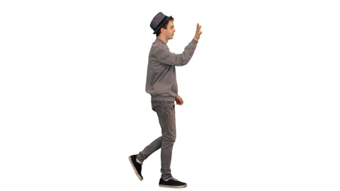 Young man in gray jacket and hat waving hand hello while walking, alpha channel Video stock 92799278