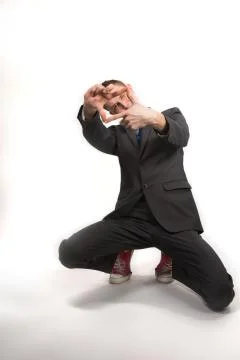 Young man in a gray jacket and red sneakers on a white background Stock Photos