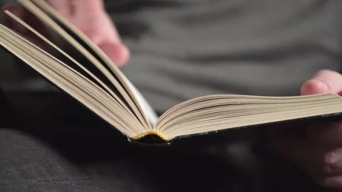 Young man in gray sweater reading a book. close-up Stock Footage 235615679