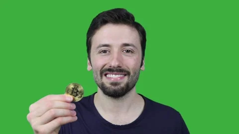 Young man on green screen is smiling while showing bitcoin Video stock 163093054