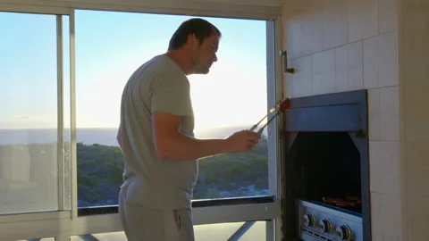 A young man grilling delicious steaks on the grill at sunset barbecue. Stock Footage 148245208