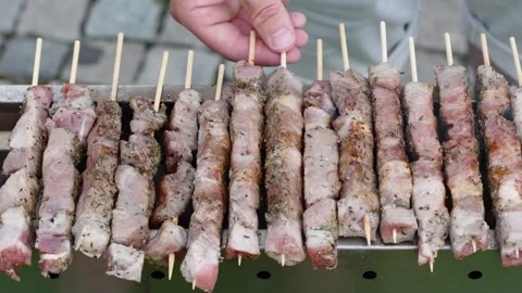 Young man grilling meat kebabs on coals, ARROSTICINI - typical southern Italian Stock Footage 284177939