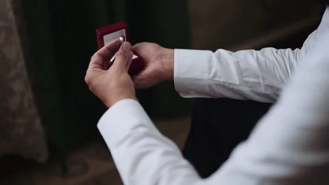 Young man (groom) look at the ring in red box and thinking about wedding. Shot Stock Footage 80954188