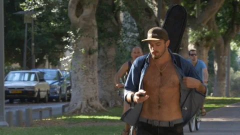 A Young Man With A Guitar Walks In The Park, Tel Aviv, Israel Stock Footage 90342296