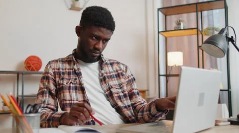Young man guy using laptop computer sitting at table working, online shopping Foto stock