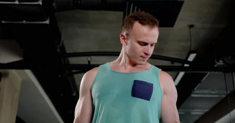 Young man in the gym doing biceps exercise using a dumbbell Stock Footage 158914459